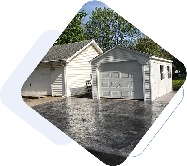 A white garage sitting in the middle of a driveway.